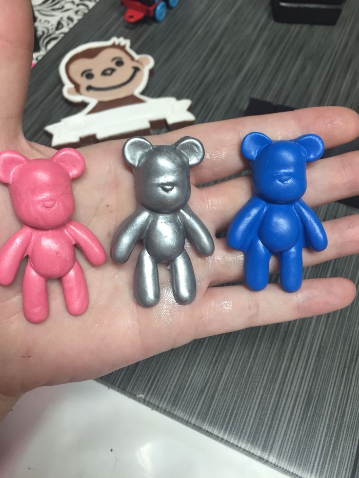 three small teddy bears sitting on the palm of someone's hand in front of them