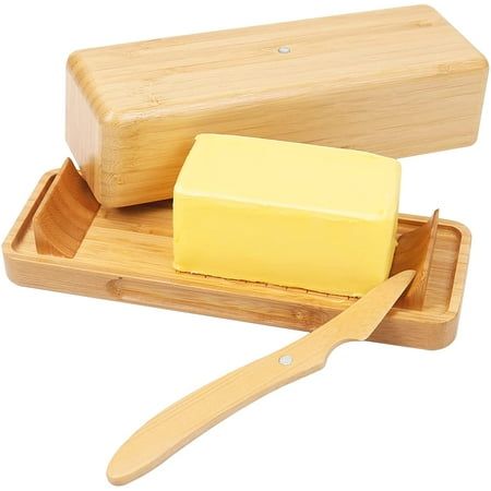 a wooden tray with cheese and a butter knife on it, next to a cutting board