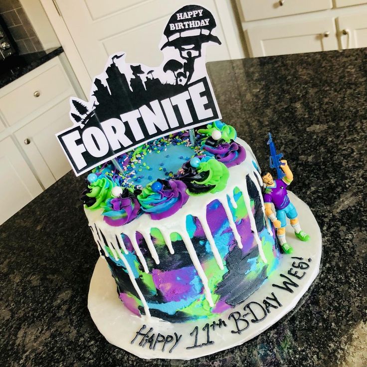 a birthday cake decorated with the name fortnite and figures on top of it