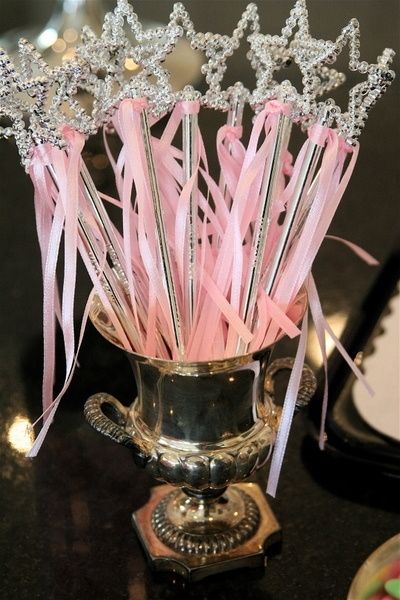 a silver vase filled with lots of pink ribbons