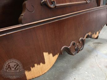 an antique wooden bed frame with metal handles