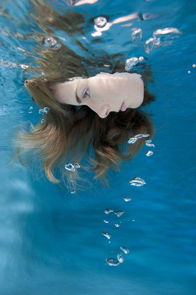 a woman with long hair floating in the water