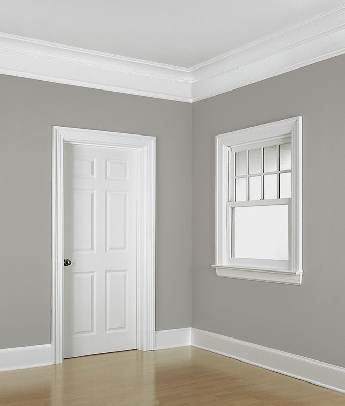 an empty room with a white door and window on the wall in front of it