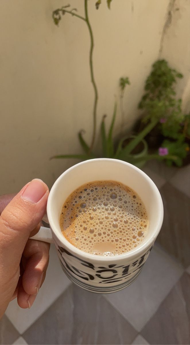 a person holding a cup of coffee in their hand