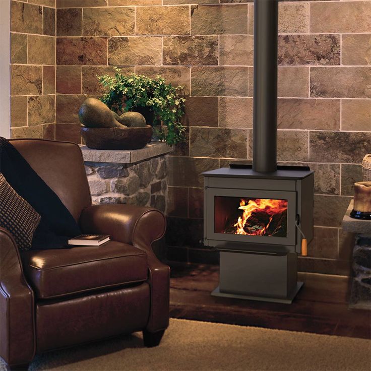 a living room with a chair, fireplace and potted plant on the side wall