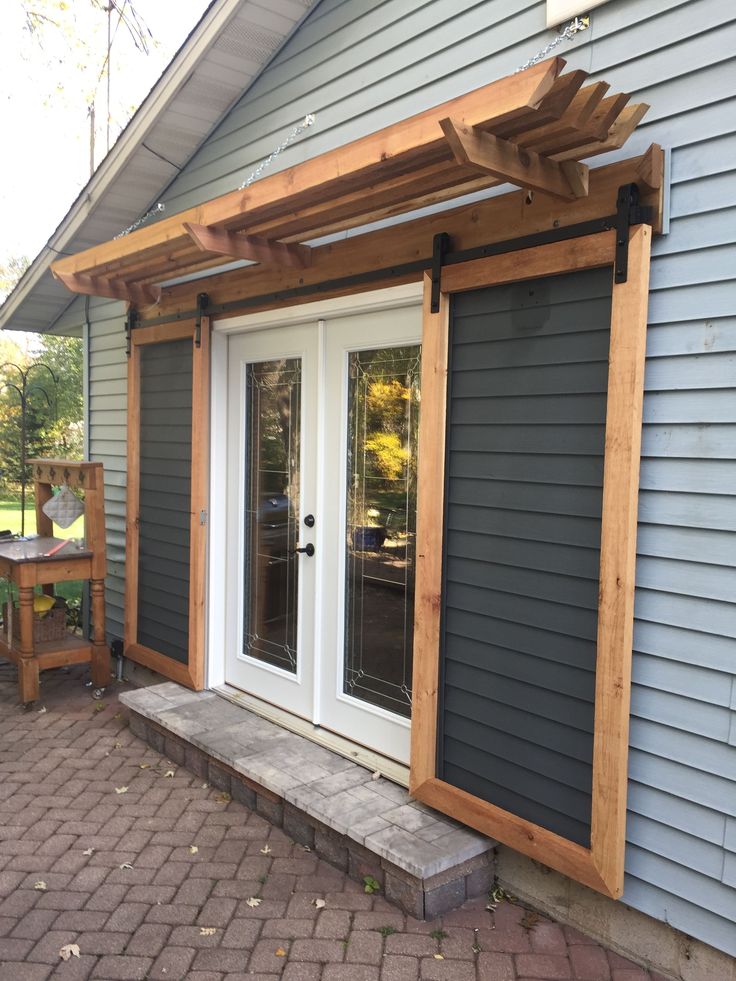 an outside patio with sliding glass doors and a pergolated trellis on the side