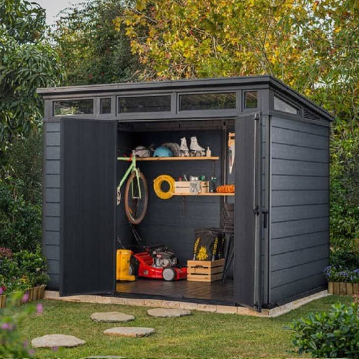 a garden shed with its doors open and tools in the storage compartment on the side