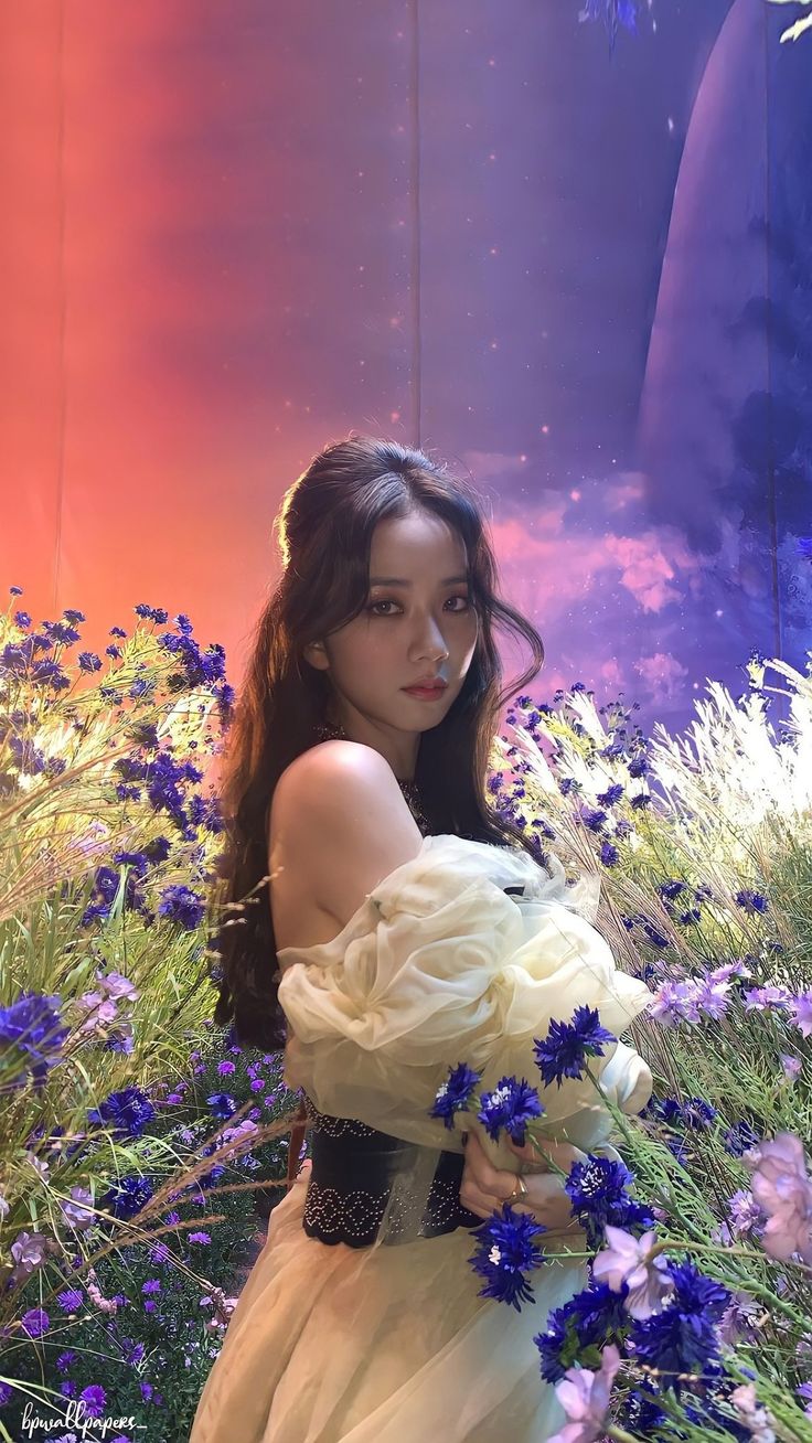 a woman in a white dress holding a bouquet of blue flowers and looking at the camera