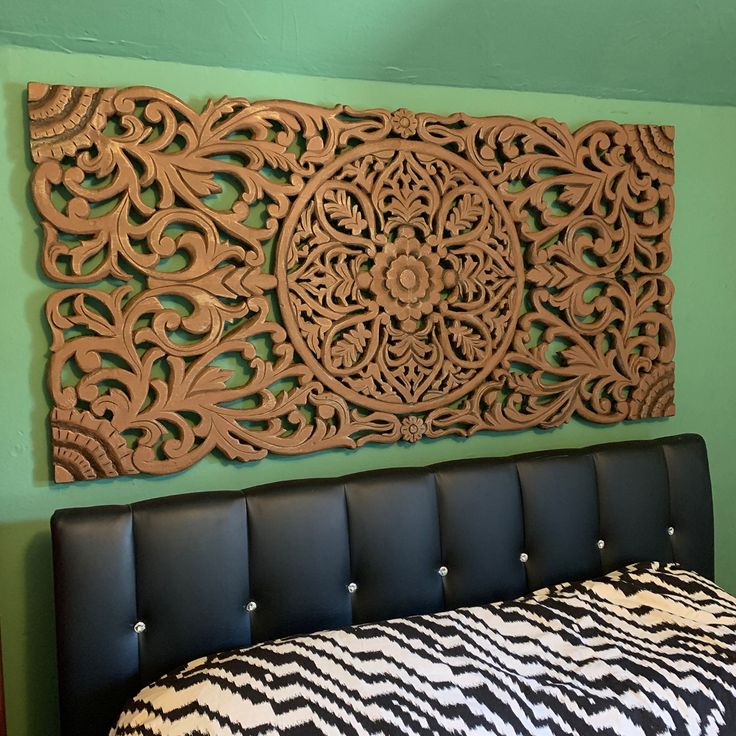 a bed with a black and white bedspread next to a green wall