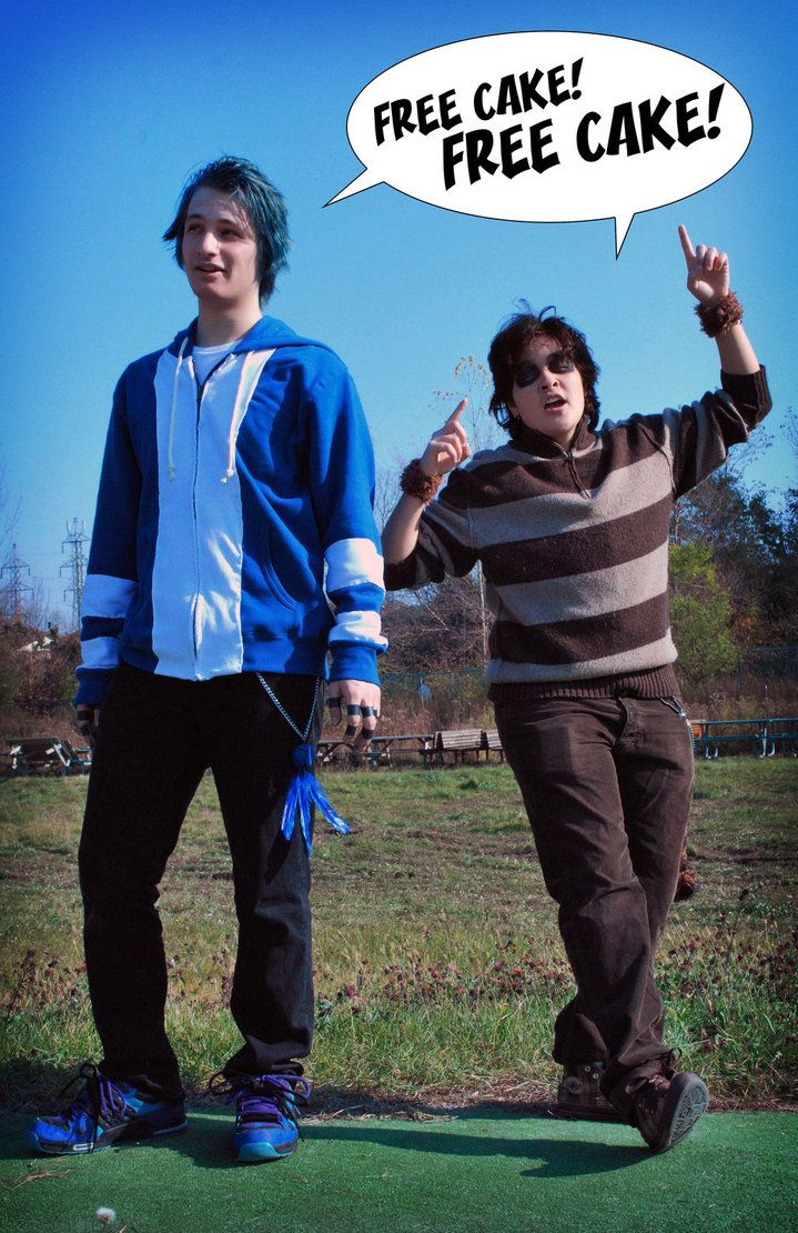 two young men standing next to each other on top of a green grass covered field