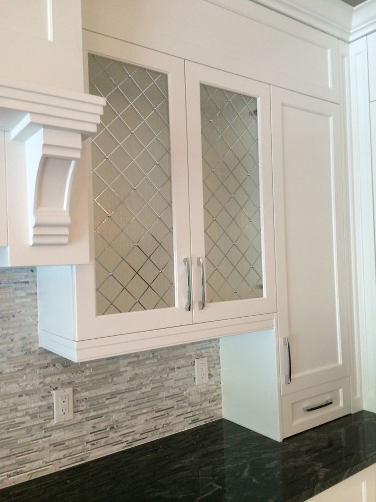 a kitchen with white cabinets and black counter tops