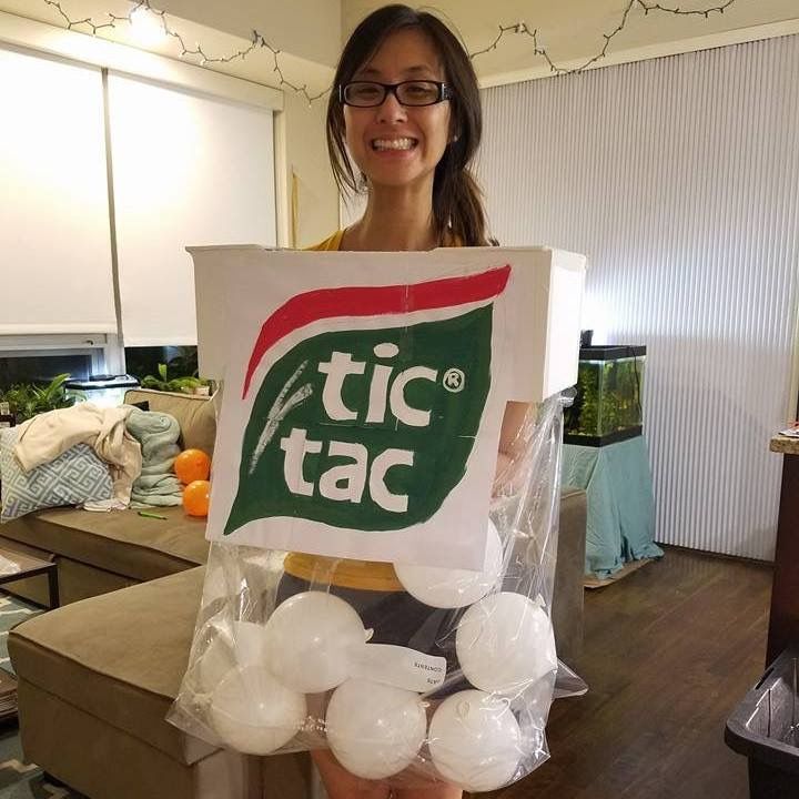 a woman holding a sign that says tic tac