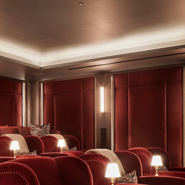 an empty theater with red seats and lamps