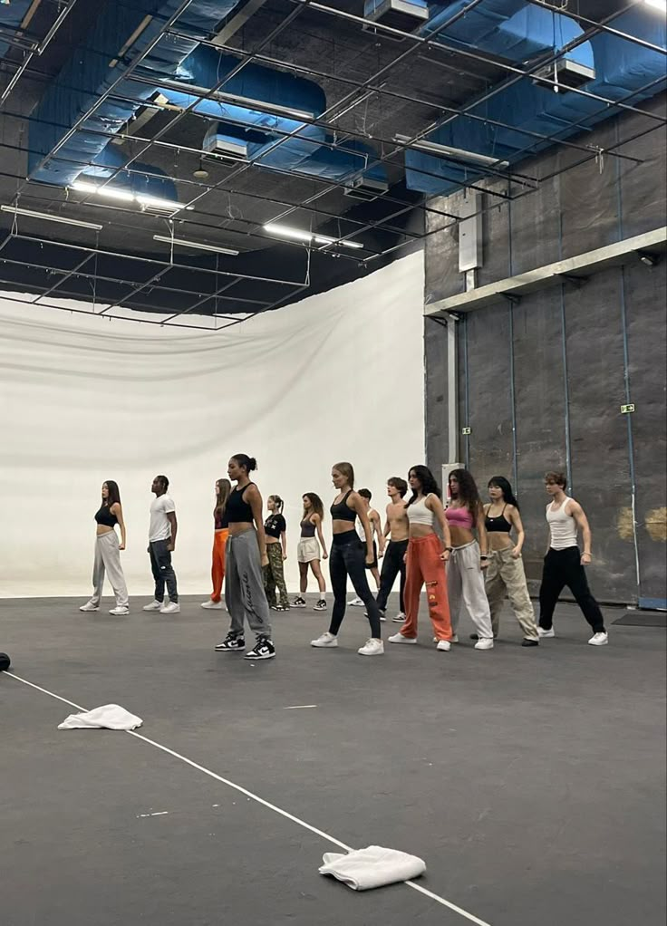 a group of young people standing in a room with white walls and blue ceilinging