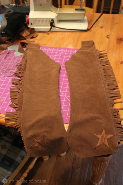 a pair of brown socks sitting on top of a wooden table next to a sewing machine