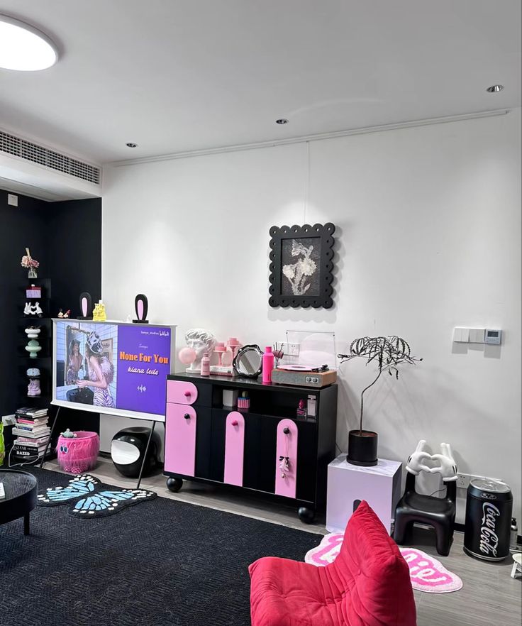 a black and white living room with pink accessories on the floor, furniture and decor