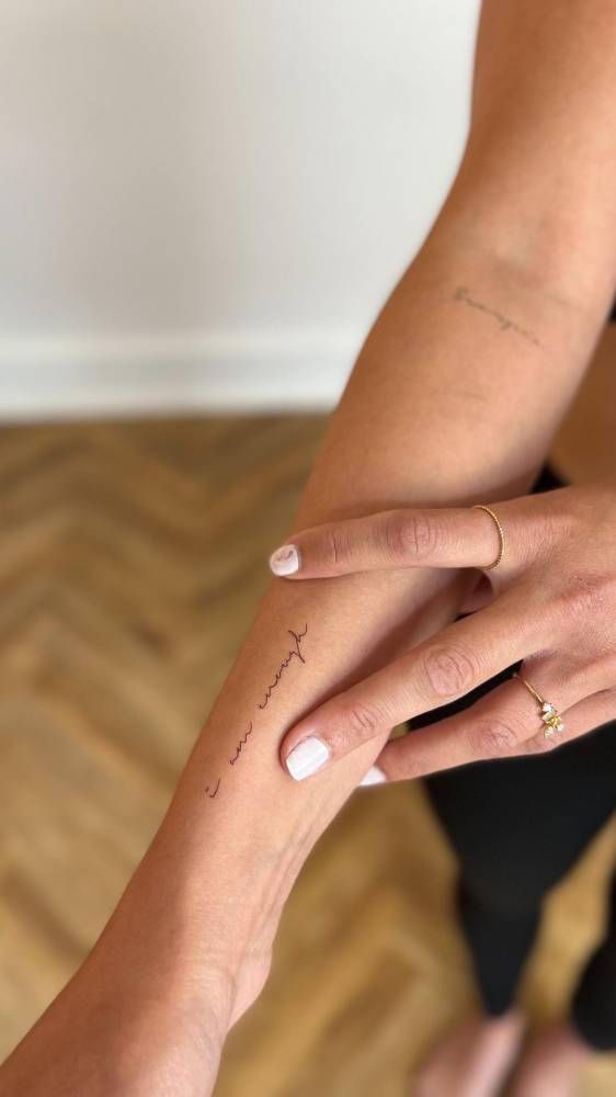 a woman's hand with a small tattoo on it