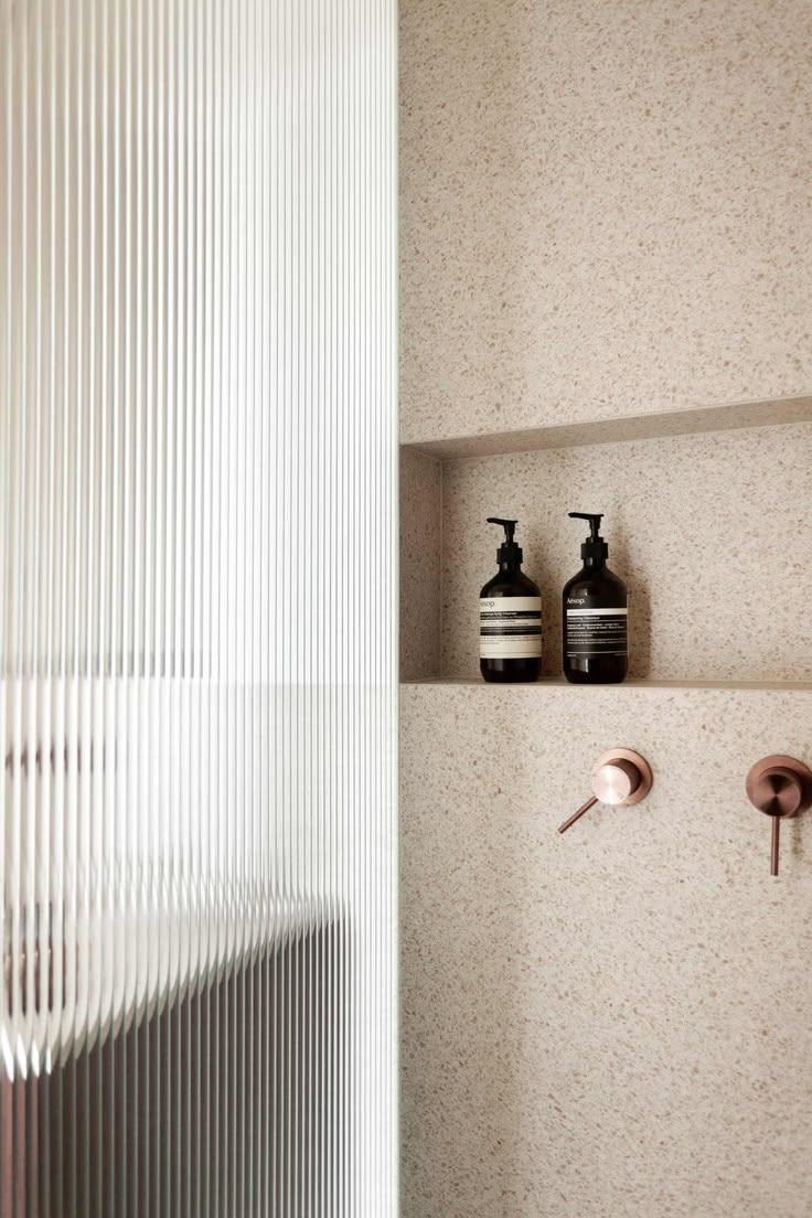 two black and white vases on the wall next to each other in a bathroom