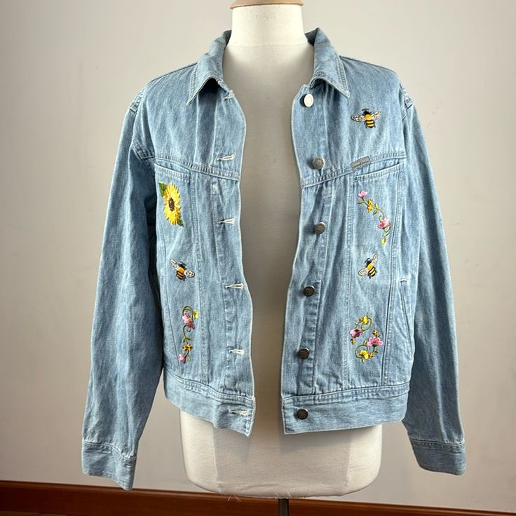 Custom Made Denim Jean Jacket With Bees And Sunflower Design. See Pictures For Details. Never Worn. Length Of Jacket Is Approximately:20 Inches. Pit To Pit Measurement Is Approximately: 20 Inches When Buttoned No Signs Of Stains Or Rips R2 Casual Outerwear With Floral Print And Relaxed Fit, Long Sleeve Cotton Denim Jacket With Floral Print, Trendy Long Sleeve Denim Jacket With Floral Print, Trendy Long Sleeve Floral Denim Jacket, Trendy Denim Floral Print Outerwear, Trendy Denim Jacket With Floral Print, Trendy Floral Print Denim Jacket, Casual Cotton Denim Jacket With Floral Print, Casual Blue Denim Jacket With Floral Print