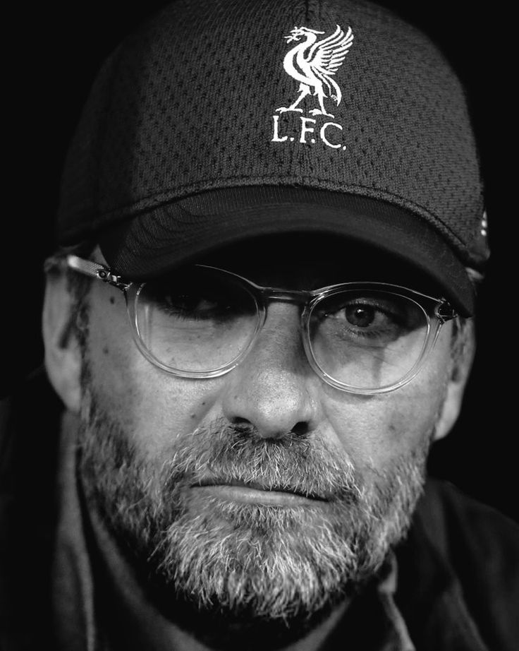 a man wearing glasses and a hat with the liverpool crest on it's side