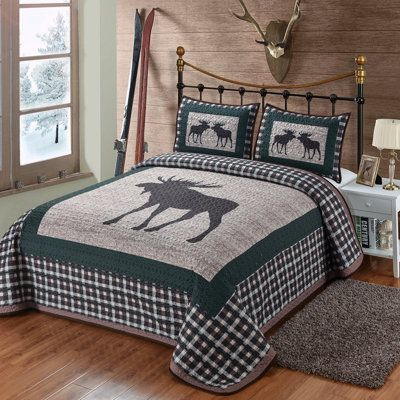 a bed with a moose quilt on it