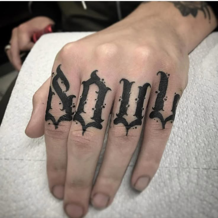 a person's hand with black ink on it and the word goth written in gothic script