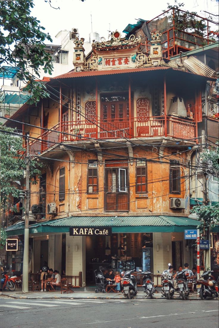 an old building with many balconies and people on motorcycles parked in front of it