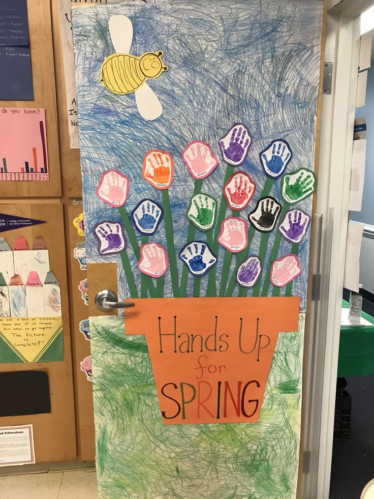 a door decorated with handprints and writing that says, hands up for spring