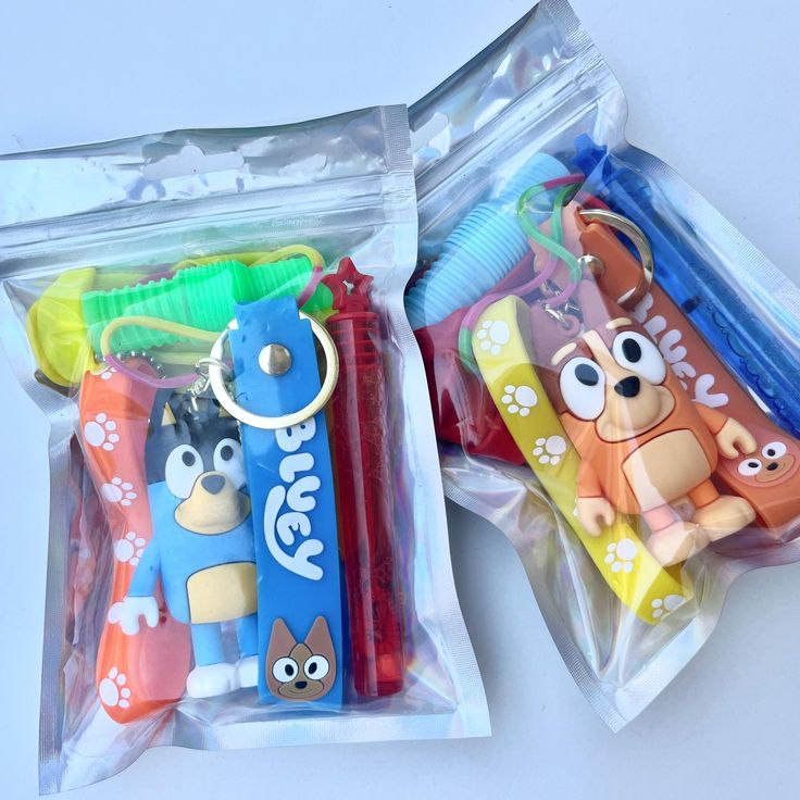 two plastic bags filled with cartoon characters and toothbrushes in each one's pouch