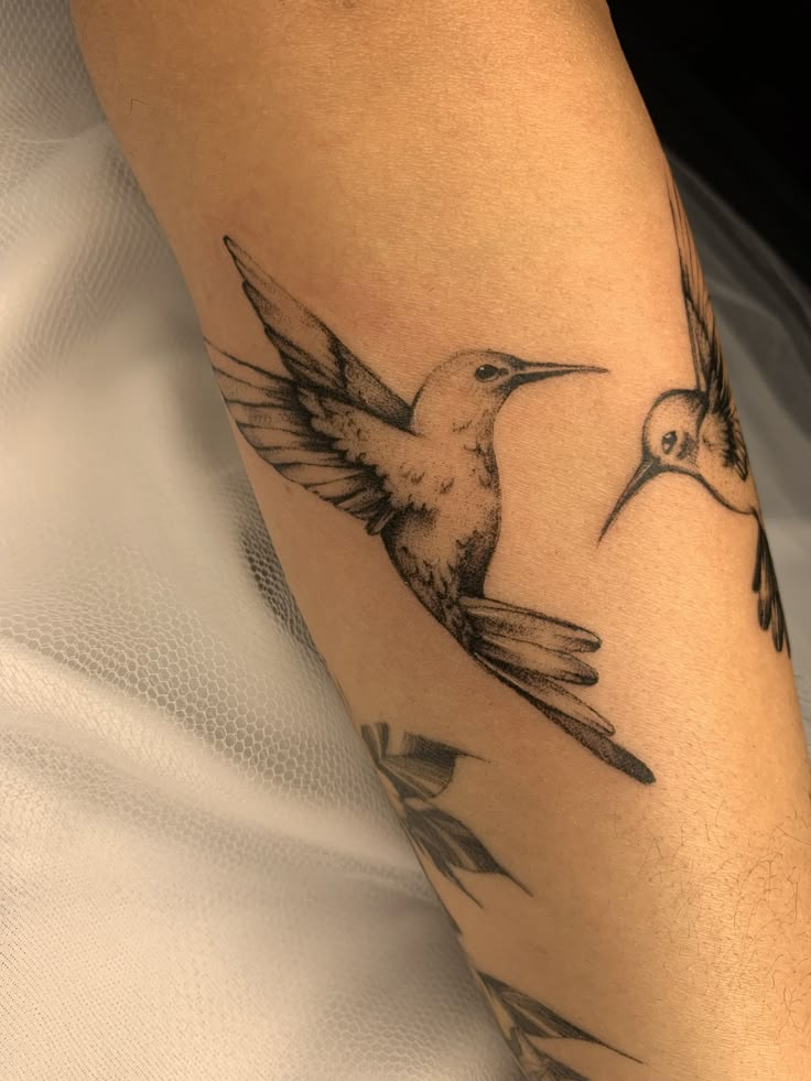 a hummingbird tattoo on the left arm