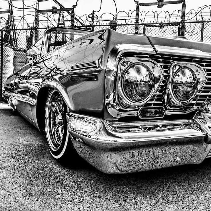 an old car parked in front of a fence