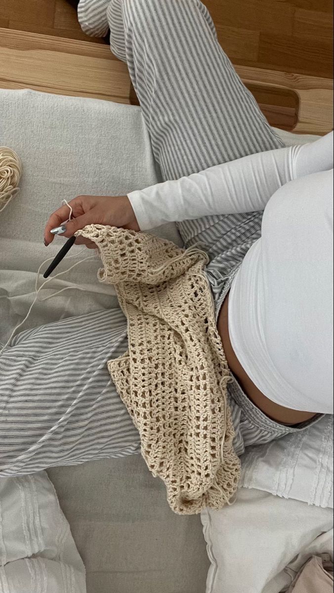 a woman laying on top of a bed holding a cell phone