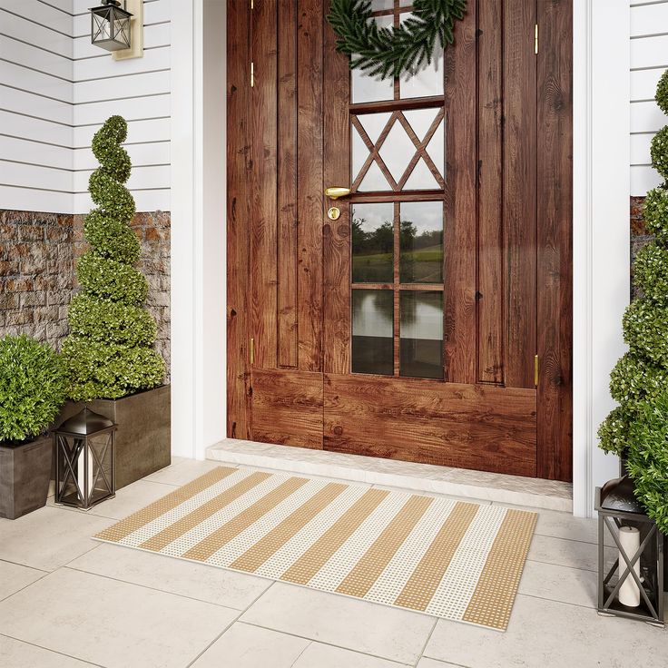 the front door is decorated with wreaths and potted plants