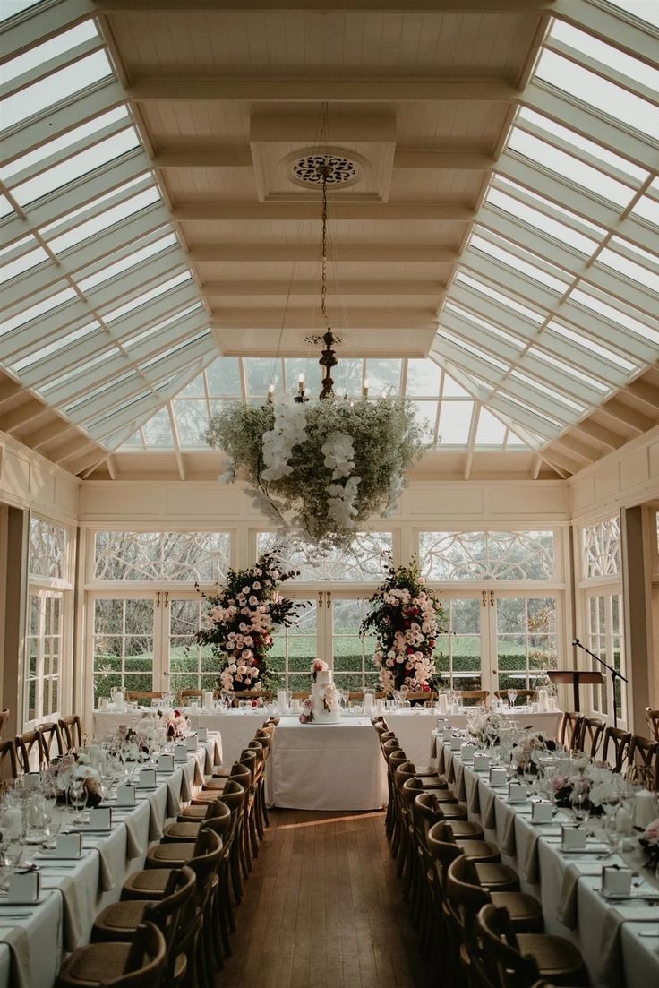 a dining room with tables and chairs set up for a formal function in front of large windows