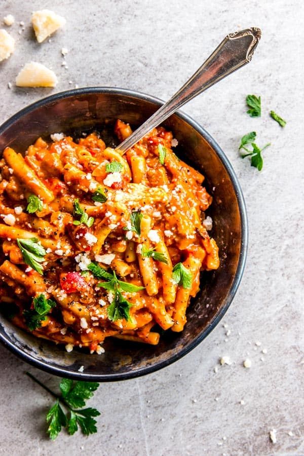 a bowl filled with pasta and topped with parsley