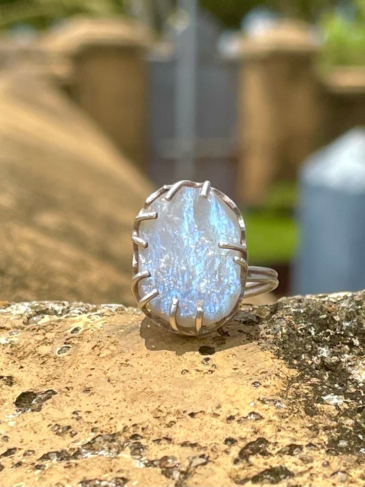 Sri Lankan Raw Moonstone & Silver Ring Handmade ring made by one of our favorite artisans, Kalumali, who comes from a family making jewelry for generations. He hand picks this stunning, glistening raw moonstone and wire claws the stone in .925 silver. The end product is a special, unique piece of jewelry from Sri Lanka. When I see moonstones I think of Sri Lanka because there is a deep connection with the moon in this culture. The semi-circular moonstone, a common architectural feature in many temples in Sri Lanka, is called Sandakada Pahana in Singhala and symbolises Samsara, the endless cycle of birth and the pains associated with it.Furthermore, Poya is the name given to the Lunar monthly Buddhist holiday of Uposatha in Sri Lanka.Poya, when the moon is full, is considered a civil and ba Spiritual Large Stone Sterling Silver Moonstone Ring, Spiritual Large Stone Moonstone Ring In Sterling Silver, Spiritual Moonstone Ring With Large Stone In Sterling Silver, Spiritual Sterling Silver Moonstone Ring With Large Stone, Unique Large Moonstone Ring, Unique Moonstone Ring With Large Stone, Handmade Fusion Style Moonstone Ring As Gift, Handmade Fusion Style Moonstone Ring For Gift, Large Stone Moonstone Ring