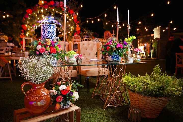 a table with flowers and candles on it in the middle of an outdoor area at night