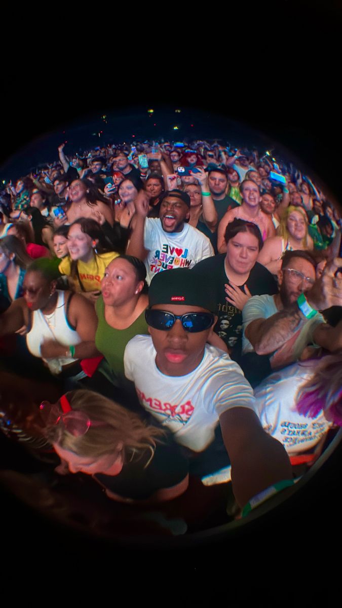 a large group of people standing in front of each other at a music festival or concert