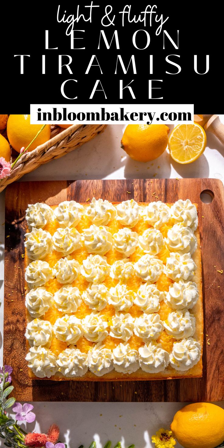 a cake with lemons and cream frosting sitting on top of a cutting board