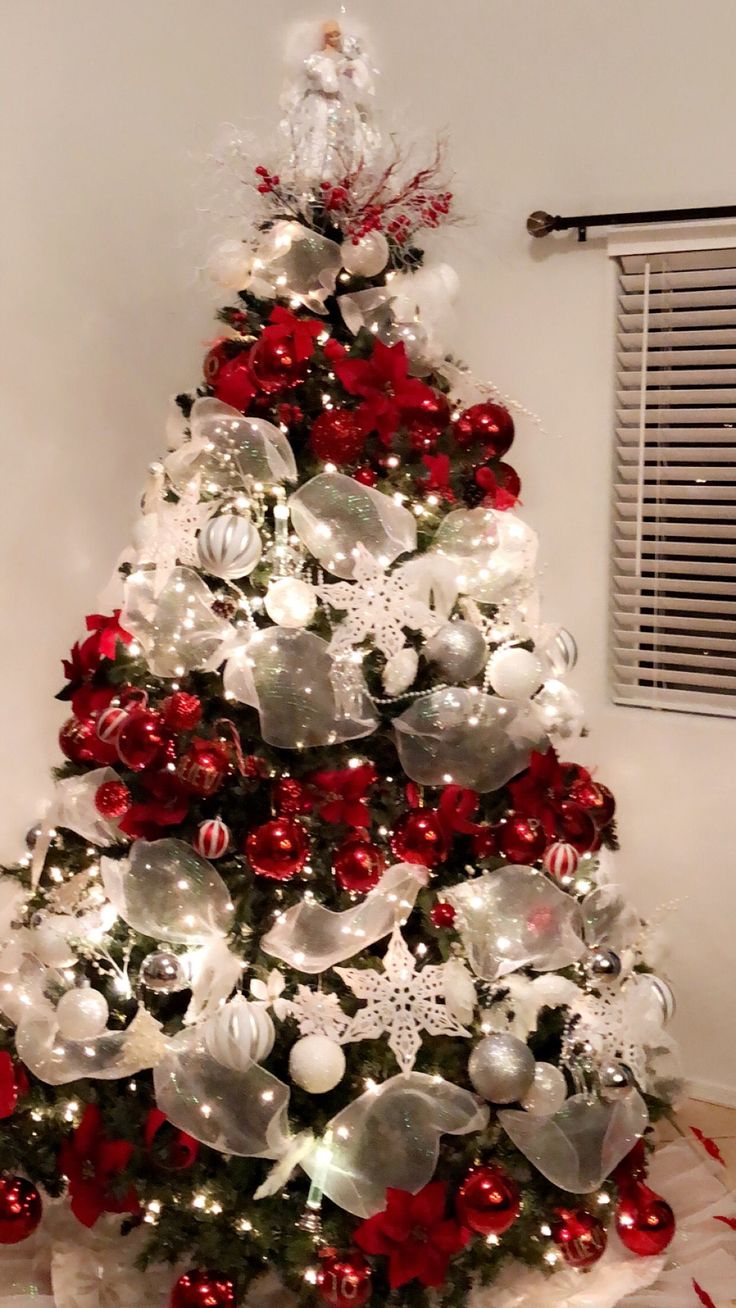 a white christmas tree with red and silver ornaments