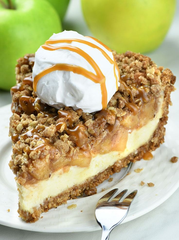 a piece of pie on a plate with whipped cream and apples in the background