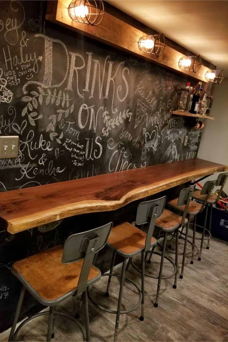 a long wooden table sitting in front of a chalkboard wall with writing on it