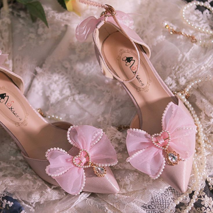 Step into elegance and charm with these exquisite pointed-toe shoes, designed to captivate and delight. The upper features a beautifully adorned bow, embellished with bead heart accents and sparkling rhinestone charms, adding a touch of whimsy and sophistication. The heel is further enhanced with a dainty bow decoration, ensuring a graceful finish from every angle. An adjustable ankle strap provides a secure and comfortable fit, making these shoes a perfect blend of style and functionality.Wheth Bead Heart, Pink Beaded, Pointed Toe Shoes, Toe Shoes, Dream Room, Pretty Dresses, Ankle Strap, Comfort Fit, Heels