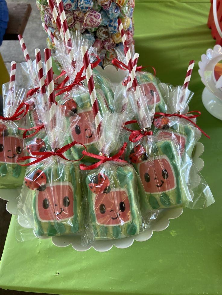 candy wrapped in cellophane and tied with red ribbon are displayed on a table