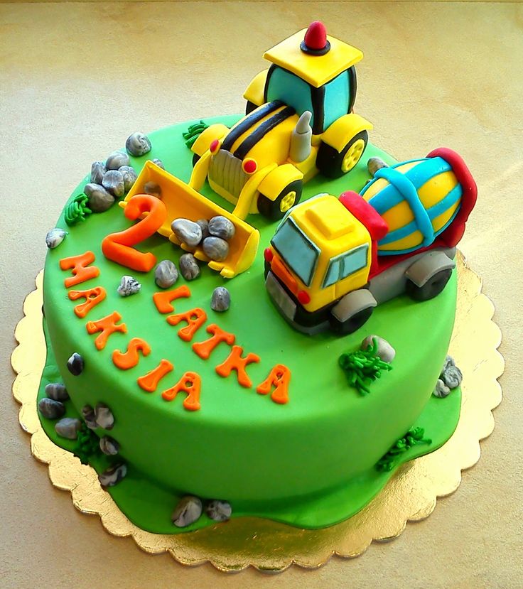 a green birthday cake with construction vehicles on it