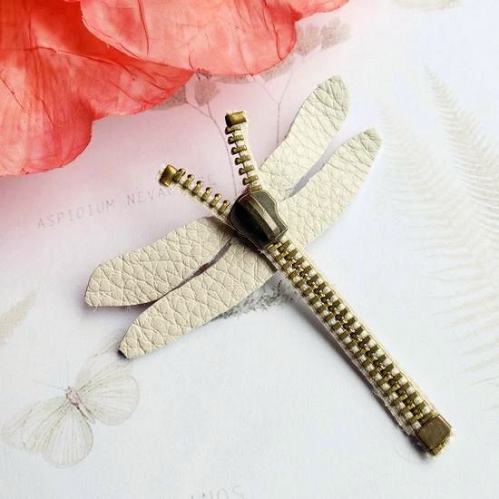 a white dragonfly pendant sitting on top of a flower