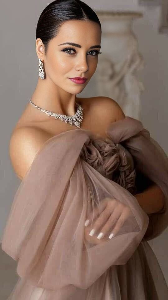 a woman in a dress and jewelry posing for the camera with her hand on her shoulder