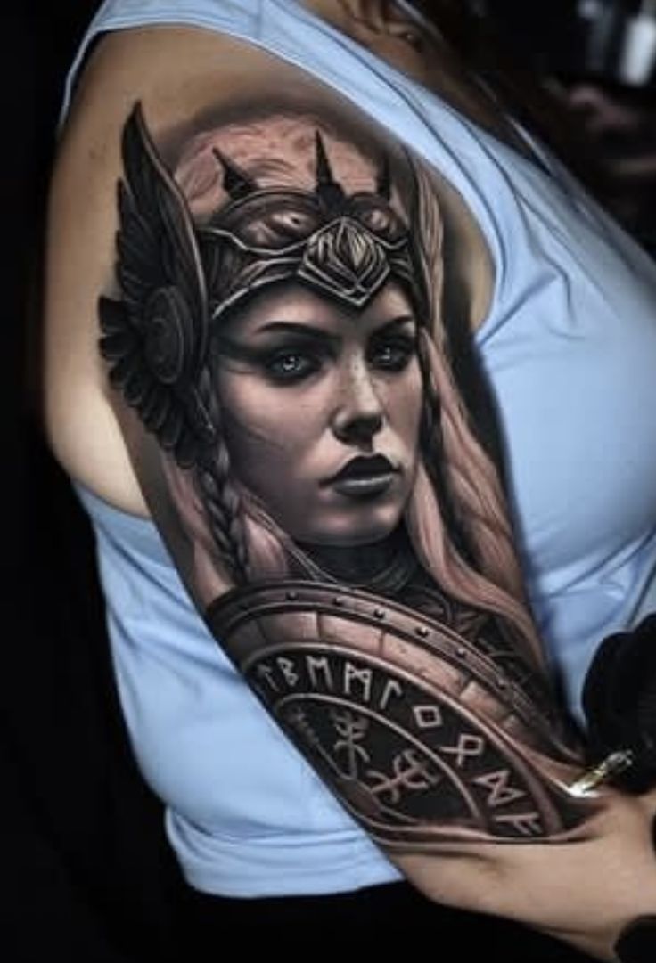 a woman's arm with a tattoo on it and an image of a warrior