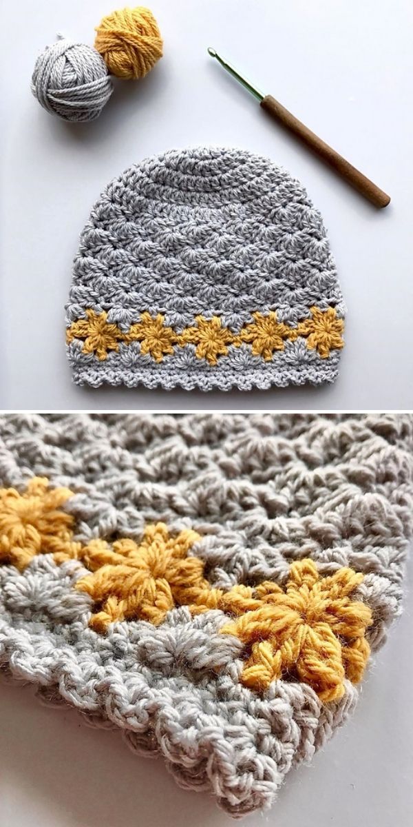 crocheted hat with yellow and gray flowers on it, next to a ball of yarn