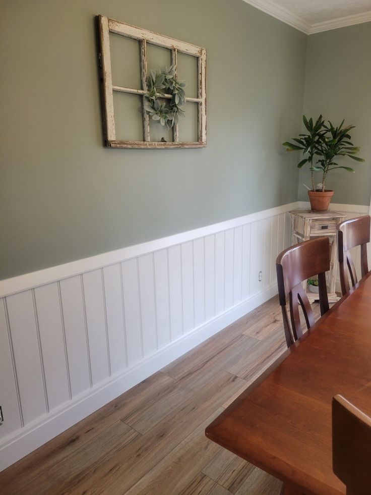 a dining room table with chairs and a potted plant